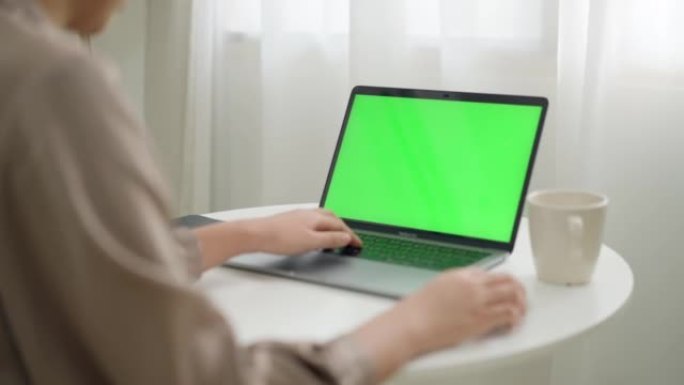 使用绿屏笔记本电脑的女人