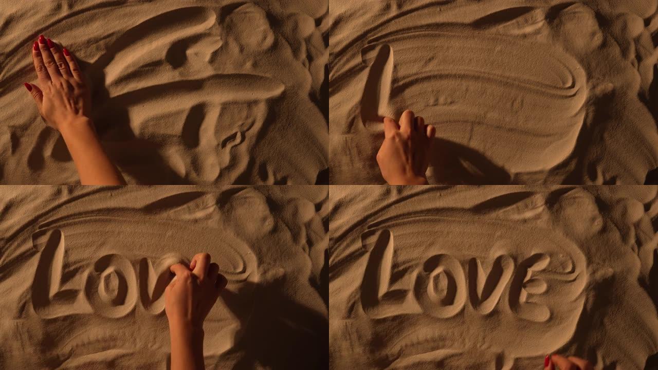 女性手抚平沙质表面，画题字爱。女人在沙滩上画画。海边的浪漫假期，爱情，夏日旅行。特写。慢动作