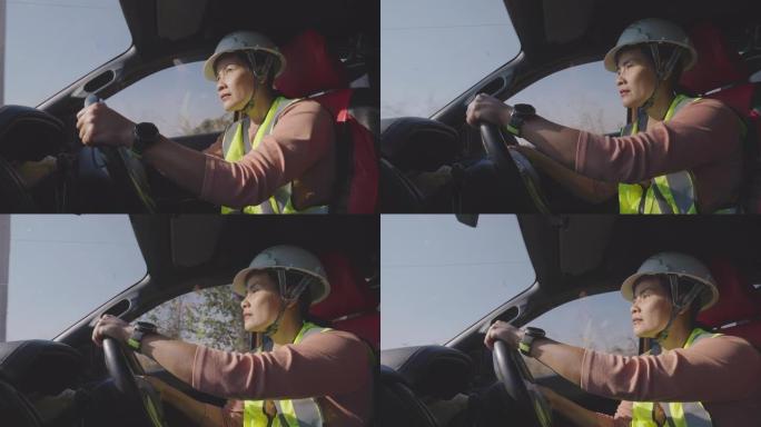 女工程师开车经过检查风车农场的工作。