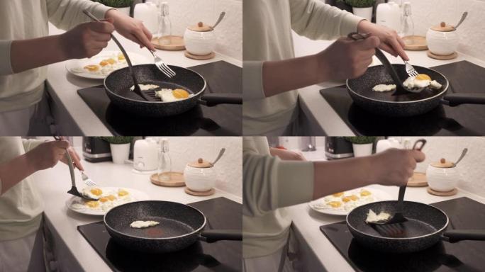 女人在厨房的电炉上煮炒鸡蛋，在电磁炉上放煎锅炒鸡蛋特写镜头