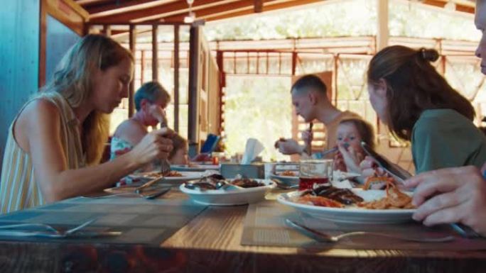一家人一起在开放式阴间的大桌子上吃饭
