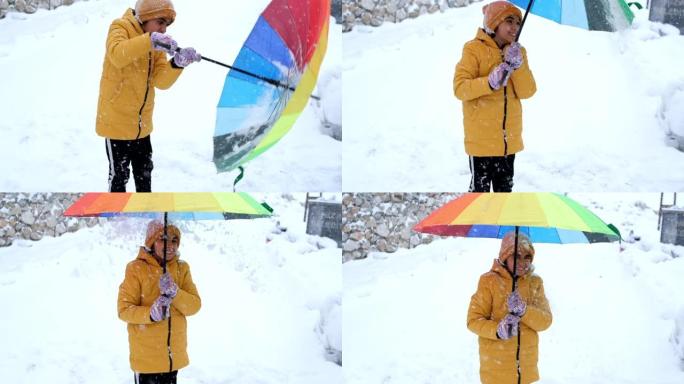 彩虹色雨伞下雪时，小女孩感到幸福