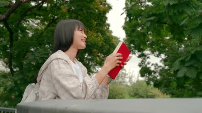 公园里拿着红皮书的女人。