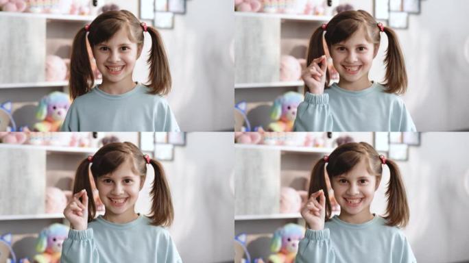 可爱的小女孩的肖像很高兴，并展示了她丢失的乳牙，并在她站在卧室时对着无牙嘴的相机微笑。快乐的女孩手里