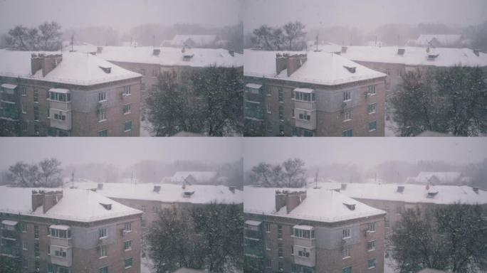 降雪落在院子里旧居民楼的屋顶上。慢动作