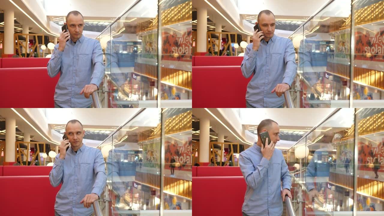 男子站在电话上，在城市购物中心内部讨论工作问题