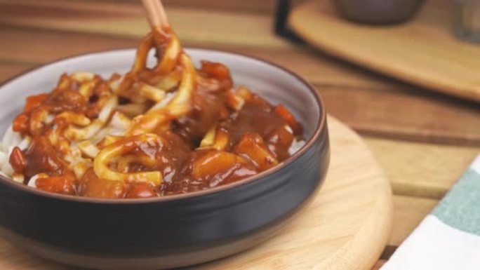 用日本美食的筷子摩擦碗咖喱面条或乌冬面的视频。准备吃饭。烹饪传统饮食概念。