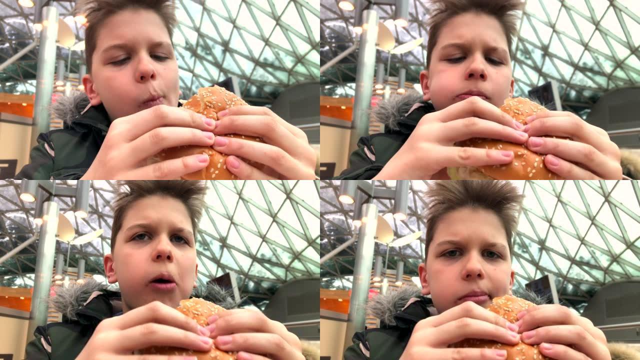 男孩在自助餐厅吃汉堡