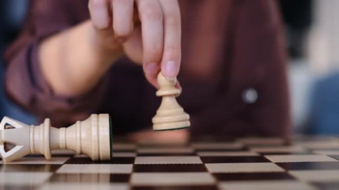 无法辨认的女人下棋。棋子在象棋比赛中击败国王。战略、管理或领导概念。慢动作视频