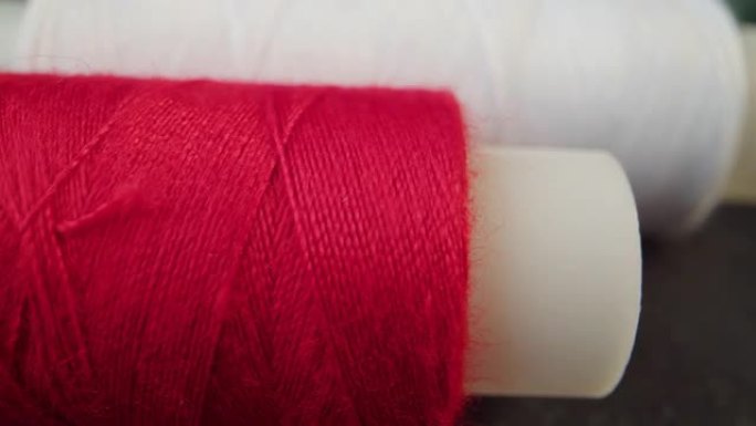 彩色线轴特写。纺织业。用针和线缝制。绣在织物上。
