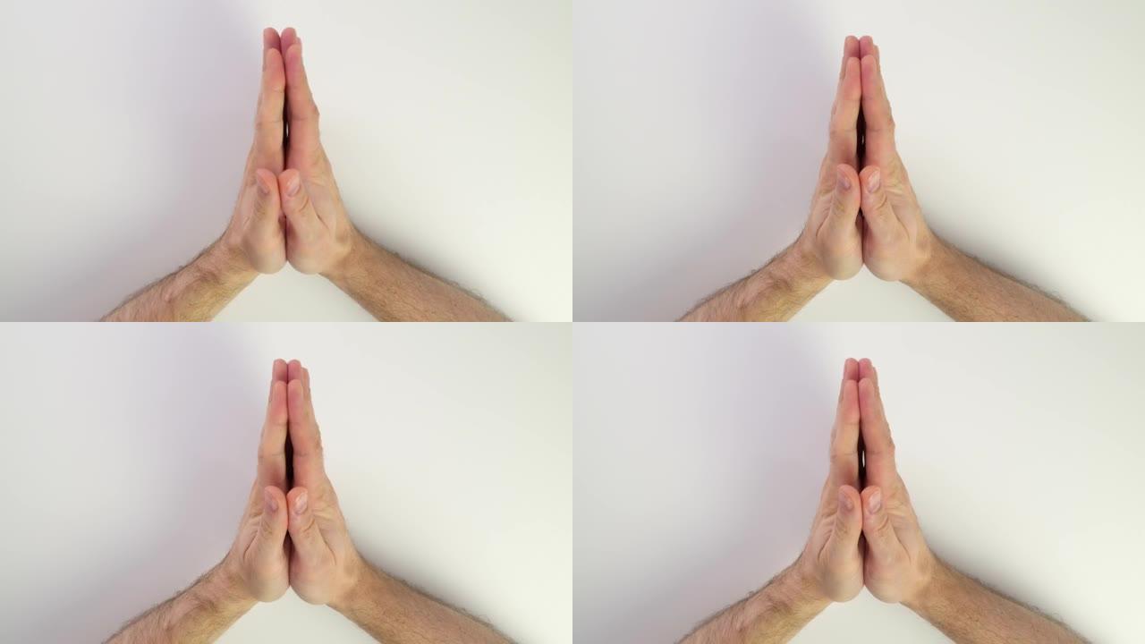 双手祈祷。白底白种人手的俯视图。手掌连接在一起。手指在右手和左手互相触摸，