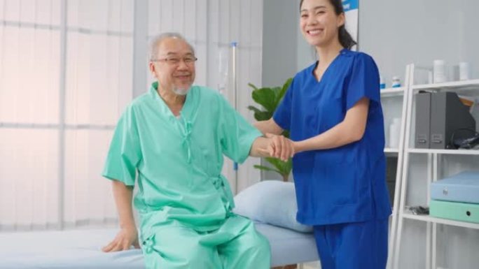亚洲女性治疗师和高级男性患者在医院的肖像。有吸引力的女性专科医生为年长的成熟男性做物理治疗程序，然后