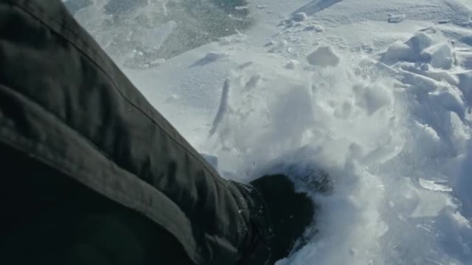 一个男人走在冰天雪地上。靴子踢到雪。美丽的冬天的风景。俄罗斯的自然地标。前视图。慢动作