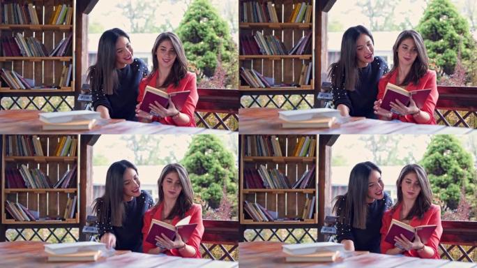 两个女性朋友坐在木桌旁看书
