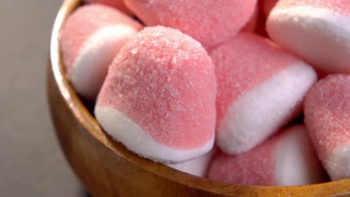 粉色白糖果酱糖果在乡村木碗。红色果冻糖果。宏
