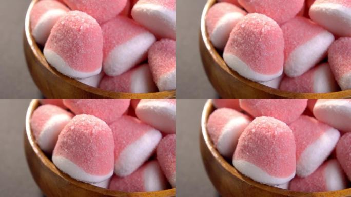 粉色白糖果酱糖果在乡村木碗。红色果冻糖果。宏