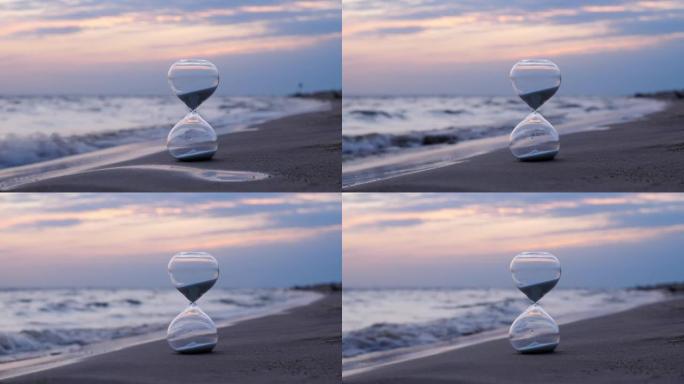 沙滩上的沙玻璃站立，小浪飞溅，背景上的日落天空