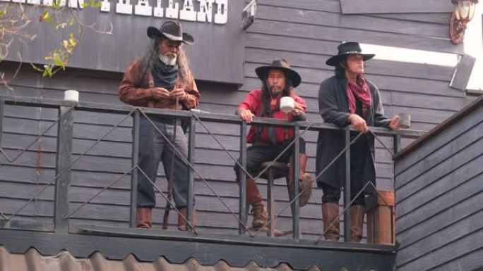 一群穿着牛仔服装的老人呆在阳台上，低头看着别人，他们有时也在一起聊天
