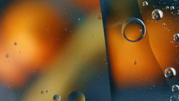 一滴油漂浮在水面上。抽象温暖的泡沫背景。