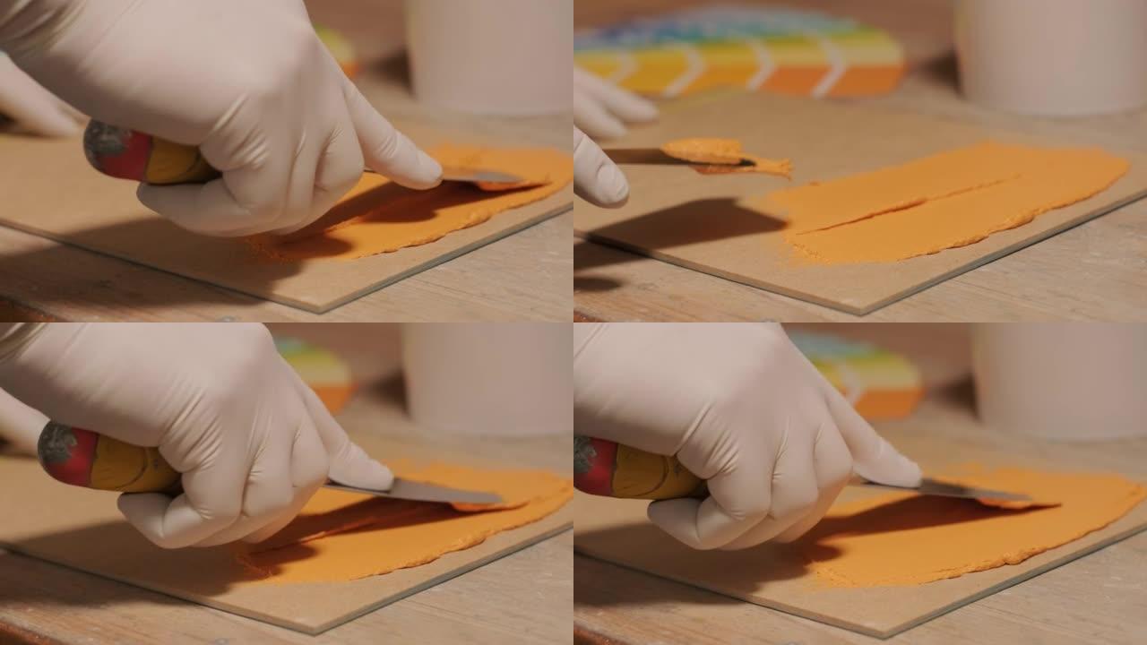 工人将油漆样本应用于调色板以进行颜色验证