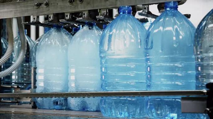 生产工厂在自动输送线上装瓶水，盖帽。