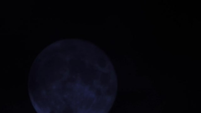 黑暗多云夜空背景下的满月