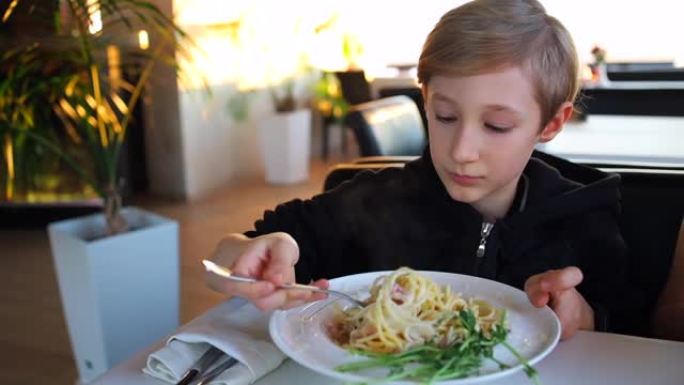 一家餐馆的孩子在叉子上扭曲carbonara糊
