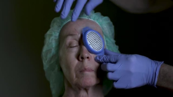白内障摘除手术后的一名高级妇女在手术的眼睛上放置了保护性眼罩。