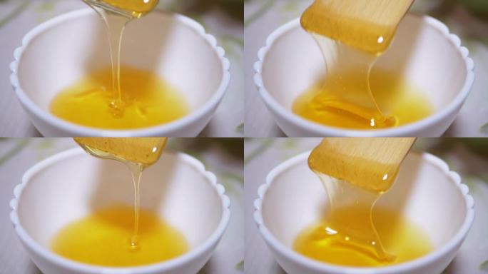 用木铲搅动，将黄色的浓蜂蜜倒入碗中。特写