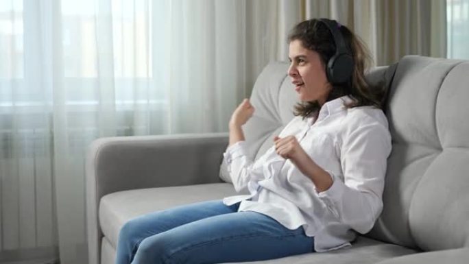 残疾妇女戴着耳机在沙发上听音乐跳舞