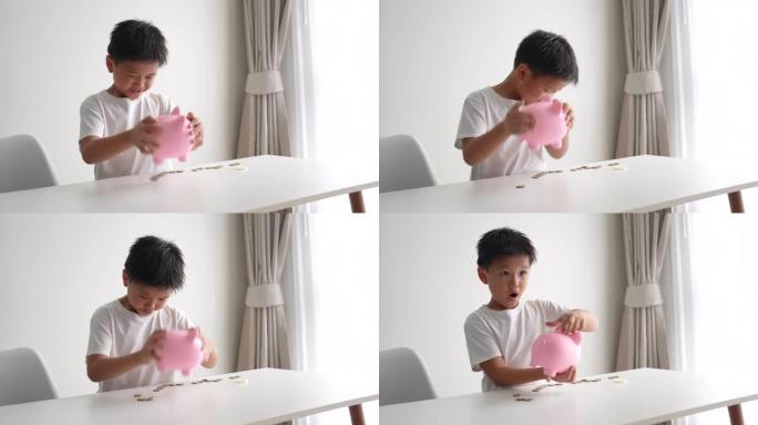 亚洲男孩在存钱罐里存钱。储蓄和银行业务的概念