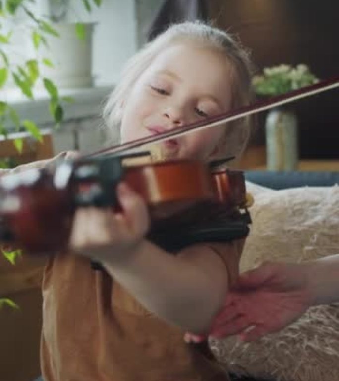 孩子学拉小提琴，老师帮她拿乐器