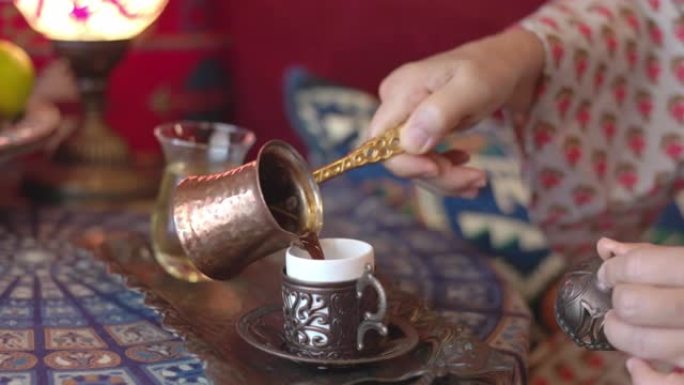 将来自塞兹韦的土耳其咖啡倒入杯中。慢动作 .....