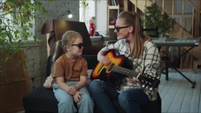 一个戴着墨镜的女人和一个孩子弹吉他，假装他们是摇滚明星