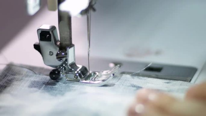 缝纫机上的缝纫特写镜头。针进入织物。针头支架