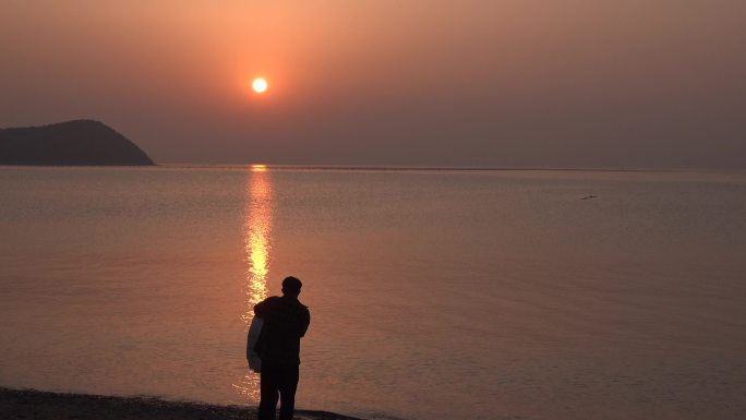 傍晚时分海边欣赏夕阳美景的情侣5