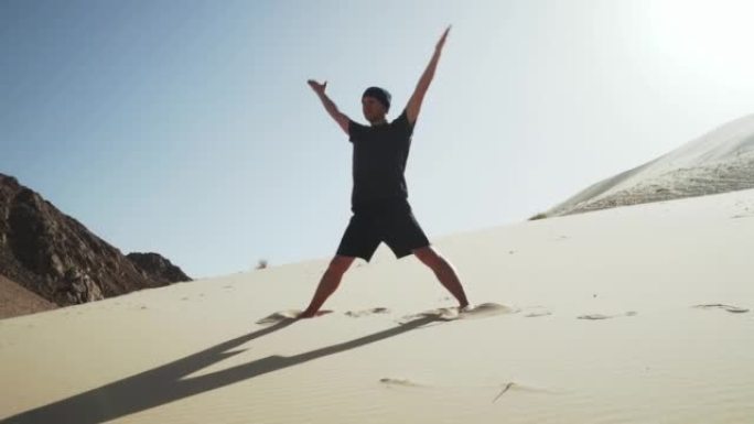 英俊的男性做瑜伽namaste trikonasana在沙漠4k的沙丘上摆姿势