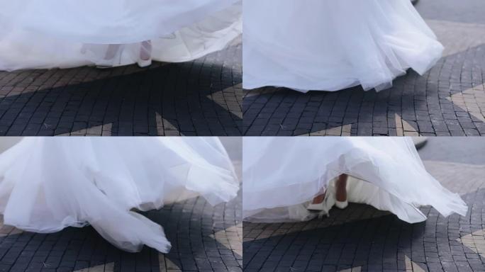 白色婚纱旋转下摆特写。新娘在街上跳舞