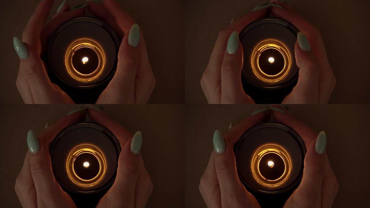 蜡烛在一个修指甲漂亮的女孩的手中充满气氛地燃烧