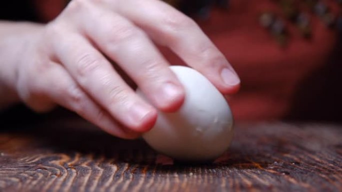 人类的手正在剥煮熟的鸡蛋