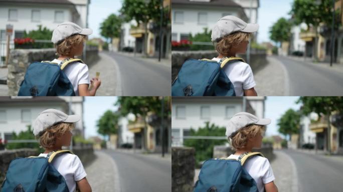 小男孩背着背包在街上行走上学