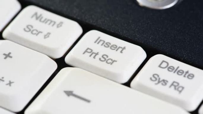 男人做一个打印屏幕，手指按下打印屏幕键，电脑键盘上的屏幕捕捉按钮，对象宏，极端特写。制作屏幕截图，保