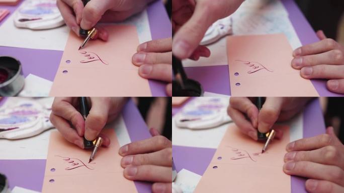 用墨水钢笔羽毛书写书法的过程，书法家在大师班用钢笔和墨水瓶在明信片纸上练习书写，手视图