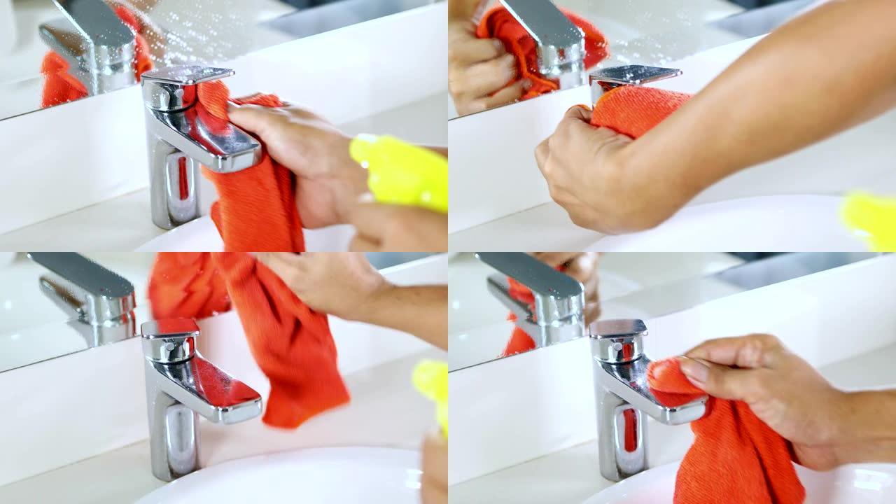 女佣用喷雾洗涤剂清洁水龙头和家里浴室水槽的视频片段。4k分辨率的专业拍摄