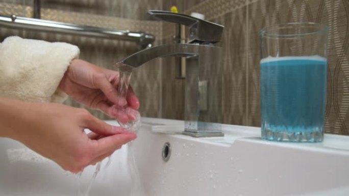 聚合物矫正器在流水下洗涤的特写。白人妇女的手正在冲洗矫正器以纠正咬伤。口腔卫生