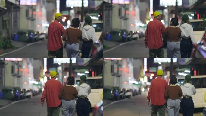 一群亚洲年轻人在台湾晚上走在街上