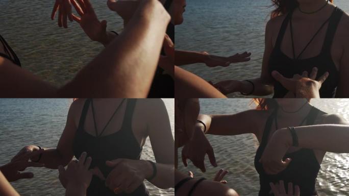 日落时在海上跳舞的女性双手的特写慢动作