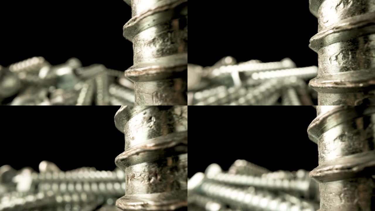 黑色背景上的部分不锈钢螺旋螺纹。金属螺钉，带螺纹的钢螺栓，用于固定。用于建筑、翻新的银螺丝锚。宏观特