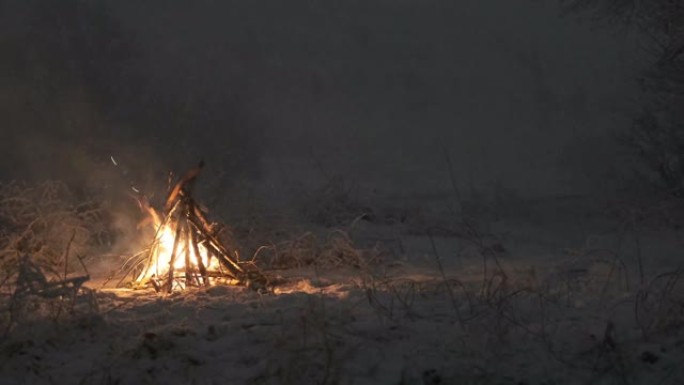 夜间在冬季森林中燃烧篝火
