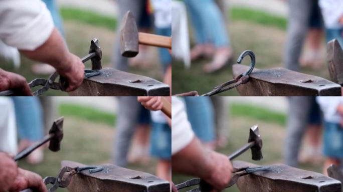 伪造马蹄铁的特写。铁匠教学徒用锤子敲击红热的马蹄铁。锻造训练。